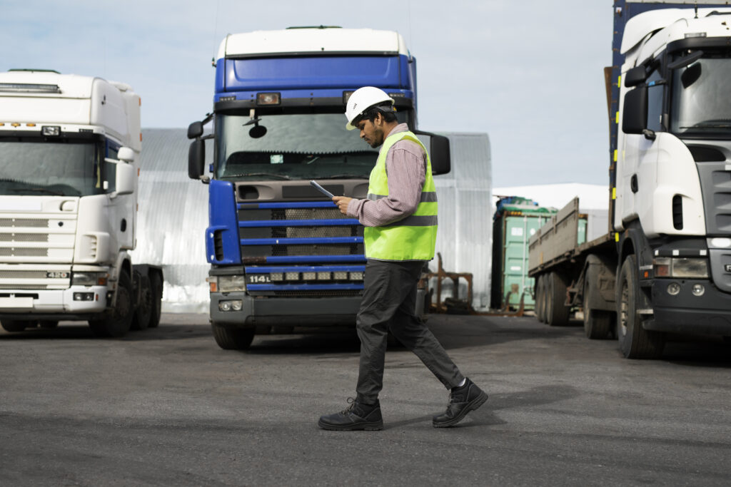 full shot man walking by trucks fleet full shot man walking by trucks fleet